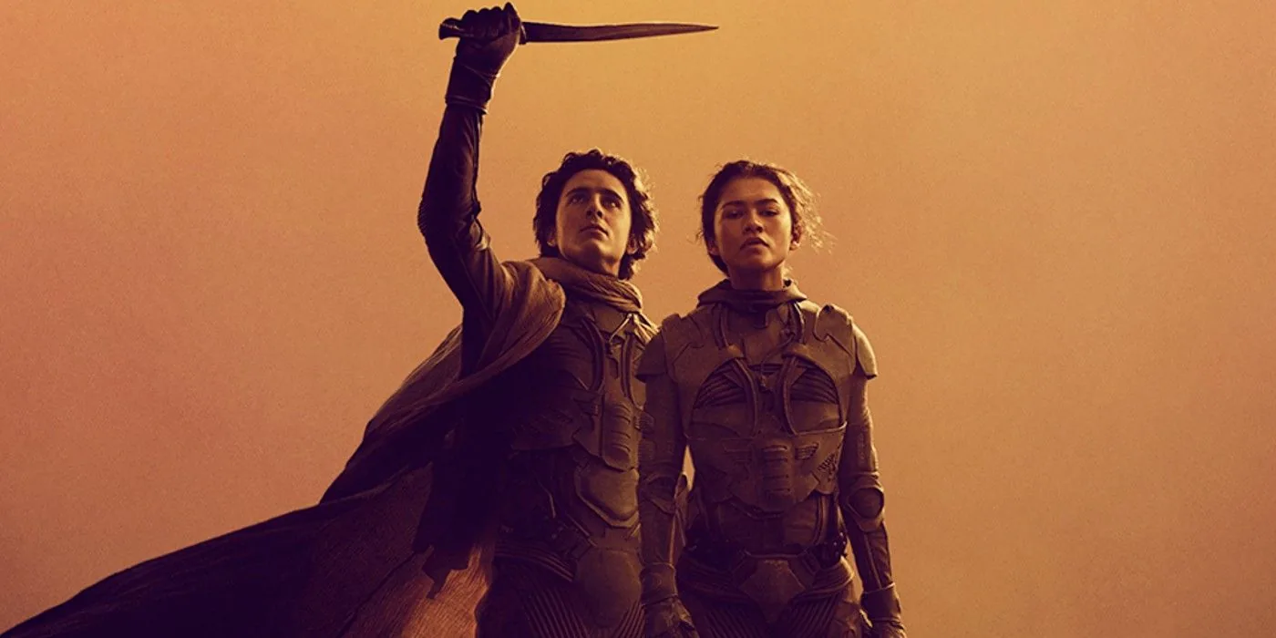 Paul Atreides and Chani standing together on the dunes of Arrakis beneath a burning sky — official key art from the Dune saga